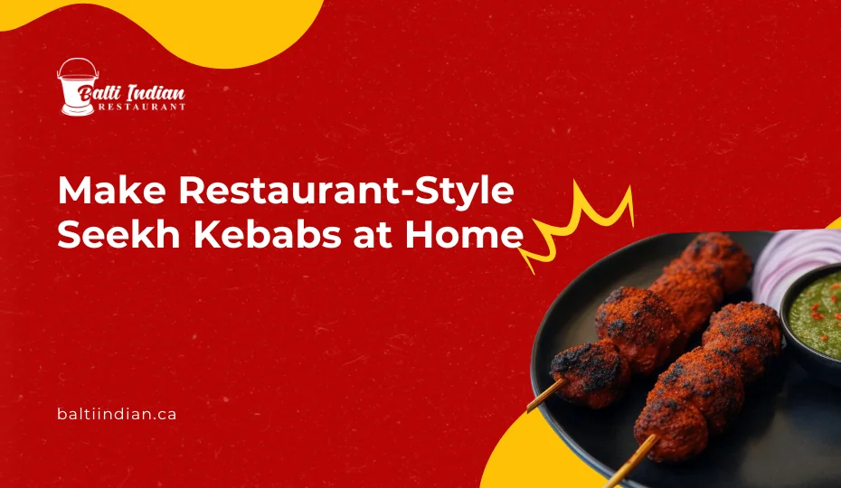 A close-up top-down view of a plate with two grilled Seekh Kababs on wooden skewers, served on a black plate. The kababs have a charred, smoky texture with a reddish-brown color and are sprinkled with red chili powder. Beside them is a portion of thinly sliced red onions, seasoned with spices, and a small bowl of green chutney with a slightly chunky texture, garnished with chopped red chilies. The background is a light marble surface, and the presentation is clean and visually appealing.